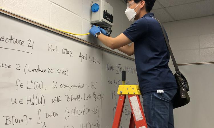 Student installs air sensor in classroom