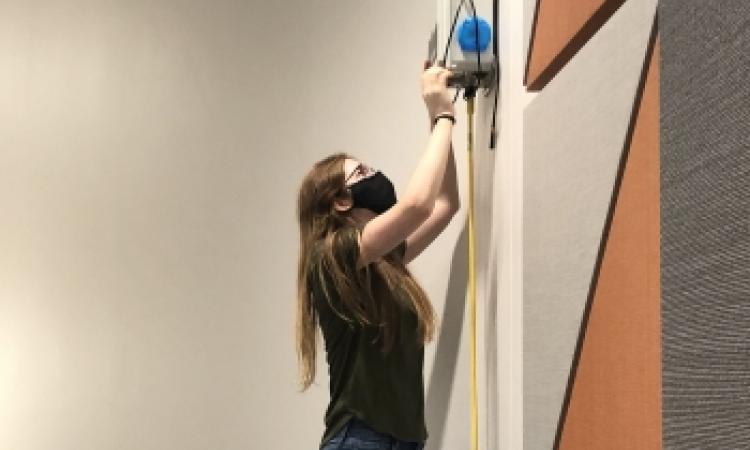 Sabrina Westage installing air sensor in classroom